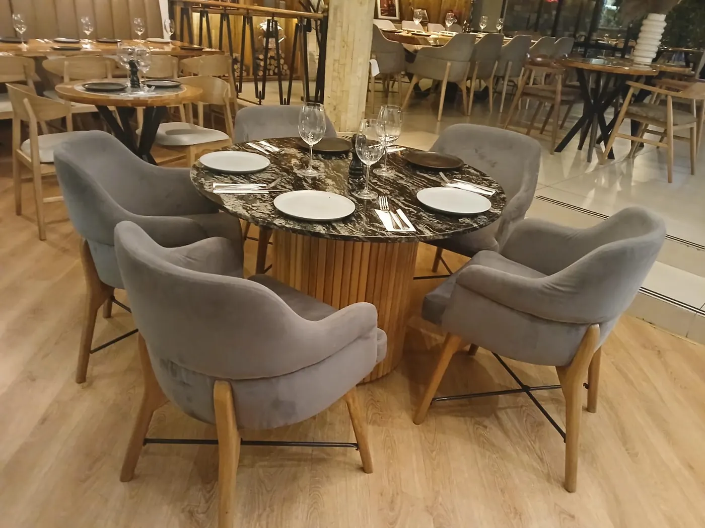 Restaurante amoblado por DOMOS: mesas con base de madera flauta, superficies en piedra natural y poltronas tapizadas
