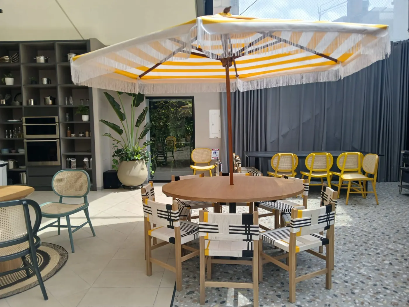 Comedor exterior de terraza con mesa redonda y sillas con tejido en cordón fabricadas por DOMOS